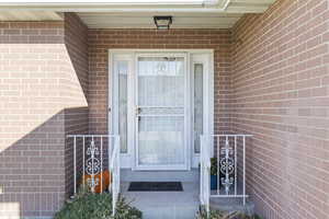 View of exterior entry featuring brick siding