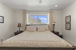 Carpeted bedroom featuring a ceiling fan and baseboards