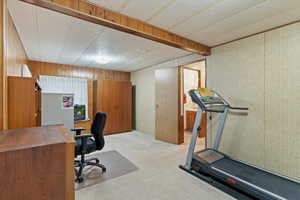 Office area with light colored carpet and wood walls