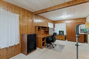 Office space with wooden walls and light carpet