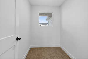 Carpeted empty room with baseboards