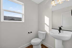 Half bathroom with baseboards and dark wood-type flooring