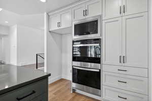 Kitchen featuring appliances with stainless steel finishes, light wood-style flooring, recessed lighting, and dark countertops