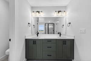 Bathroom featuring double vanity and a shower stall