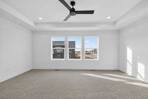 Spare room with light colored carpet, a tray ceiling, a ceiling fan, and recessed lighting