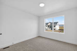 Carpeted empty room with baseboards