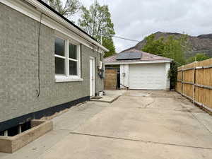 Detached garage featuring concrete driveway and solar panels