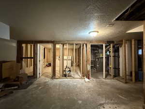 Miscellaneous room with gas water heater, a textured ceiling, and heating unit