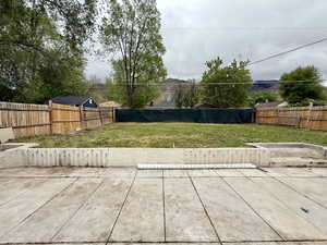 Fenced backyard with a large patio and grass areaview of the mountains