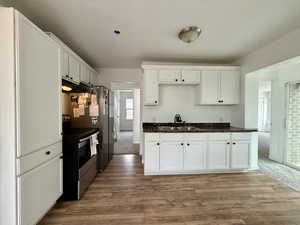 Kitchen featuring white cabinets, stainless steel appliances, and dark wood finished floors