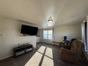 Living area with dark carpet and baseboards