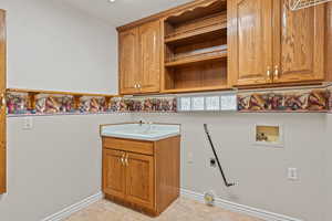 Laundry room featuring cabinet space, hookup for a washing machine, electric dryer hookup, light tile patterned flooring, and hookup for a gas dryer