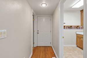 Hallway featuring a textured ceiling and light wood finished floors