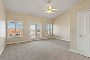 Spare room featuring a ceiling fan, light carpet, and vaulted ceiling