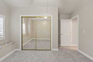 Unfurnished bedroom with a closet, light carpet, and a ceiling fan