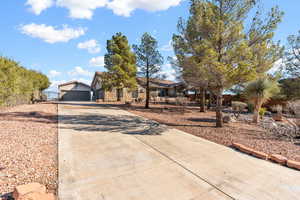 View of front of property with concrete driveway and an outdoor structure