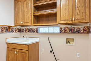 Laundry area with hookup for a washing machine, cabinet space, and electric dryer hookup