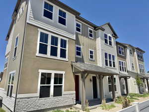 View of front of property featuring board and batten siding, stucco siding, a porch, and a residential view