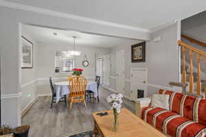 Living room featuring crown molding, wood finished floors, stairway, and a textured ceiling