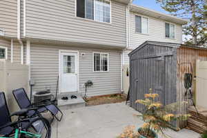 Back of house with a storage shed and a patio area