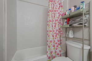 Bathroom featuring shower / tub combo and toilet