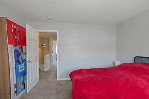 Bedroom featuring light colored carpet and a textured ceiling