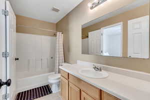Full bathroom featuring shower / tub combo with curtain, vanity, and light tile patterned flooring