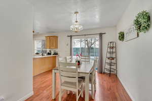 Dining area featuring plenty of natural light, light wood finished floors, and a chandelier