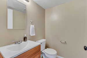 Half bath featuring vanity and a textured ceiling