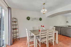 Dining room featuring light wood-type flooring and a chandelier