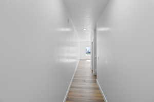 Hallway featuring baseboards and wood finished floors