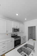 Kitchen featuring stainless steel appliances, white cabinets, and recessed lighting