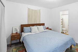 Bedroom with baseboards and connected bathroom