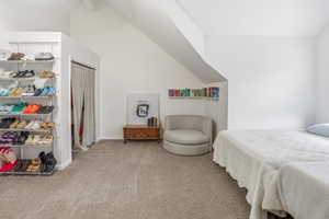 Bedroom with light colored carpet and lofted ceiling