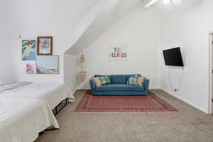 Bedroom with carpet, high vaulted ceiling, and a ceiling fan