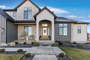 View of exterior entry with stone siding and a yard