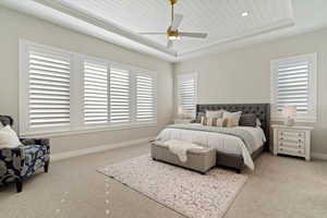 Bedroom with a raised ceiling, wood ceiling, carpet, and ceiling fan