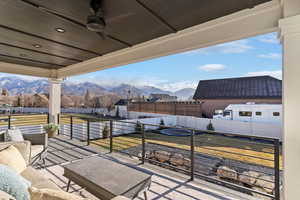 Fenced backyard featuring a mountain view, an outdoor living space, and a ceiling fan