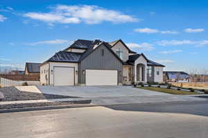 Modern farmhouse style home featuring board and batten siding, concrete driveway, a garage, and a shingled roof