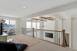 Hall featuring beamed ceiling, carpet, coffered ceiling, recessed lighting, and an upstairs landing