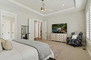 Carpeted bedroom with wood ceiling, a ceiling fan, a raised ceiling, and recessed lighting