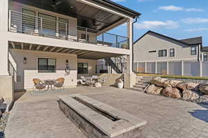 Back of property with stairs, a patio area, outdoor dining area, a balcony, and an outdoor hangout area