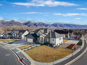 View of front facade with concrete driveway, a residential view, board and batten siding, a mountain view, and a garage