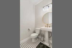 Half bath with baseboards and tile patterned floors