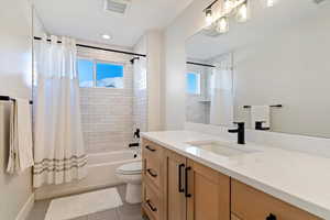Full bathroom featuring shower / tub combo with curtain, vanity, and light tile patterned floors