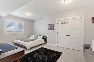Carpeted bedroom featuring baseboards and a closet