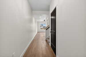 Hall with light wood-style flooring and stairs