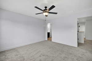 Unfurnished bedroom with light colored carpet and a ceiling fan