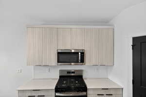 Kitchen featuring light stone countertops, stainless steel appliances, modern cabinets, and backsplash