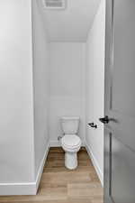 Bathroom featuring light wood finished floors and toilet